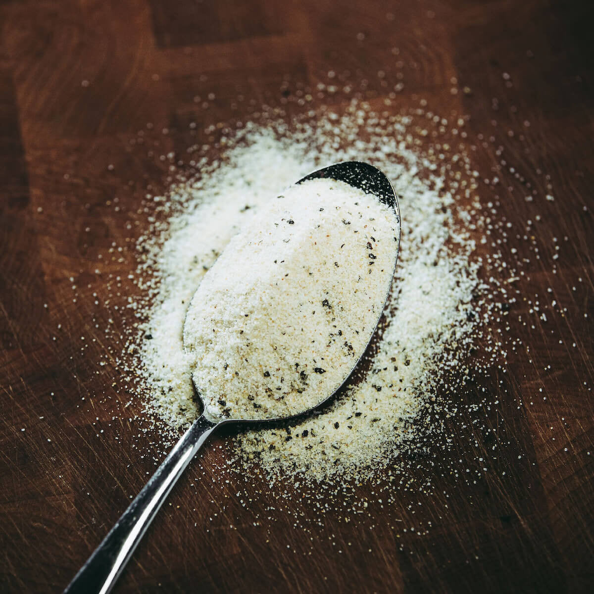 Chef Greg's Four Letter Rub All Purpose Deliciousness on spoon showing the spice out of bottle.