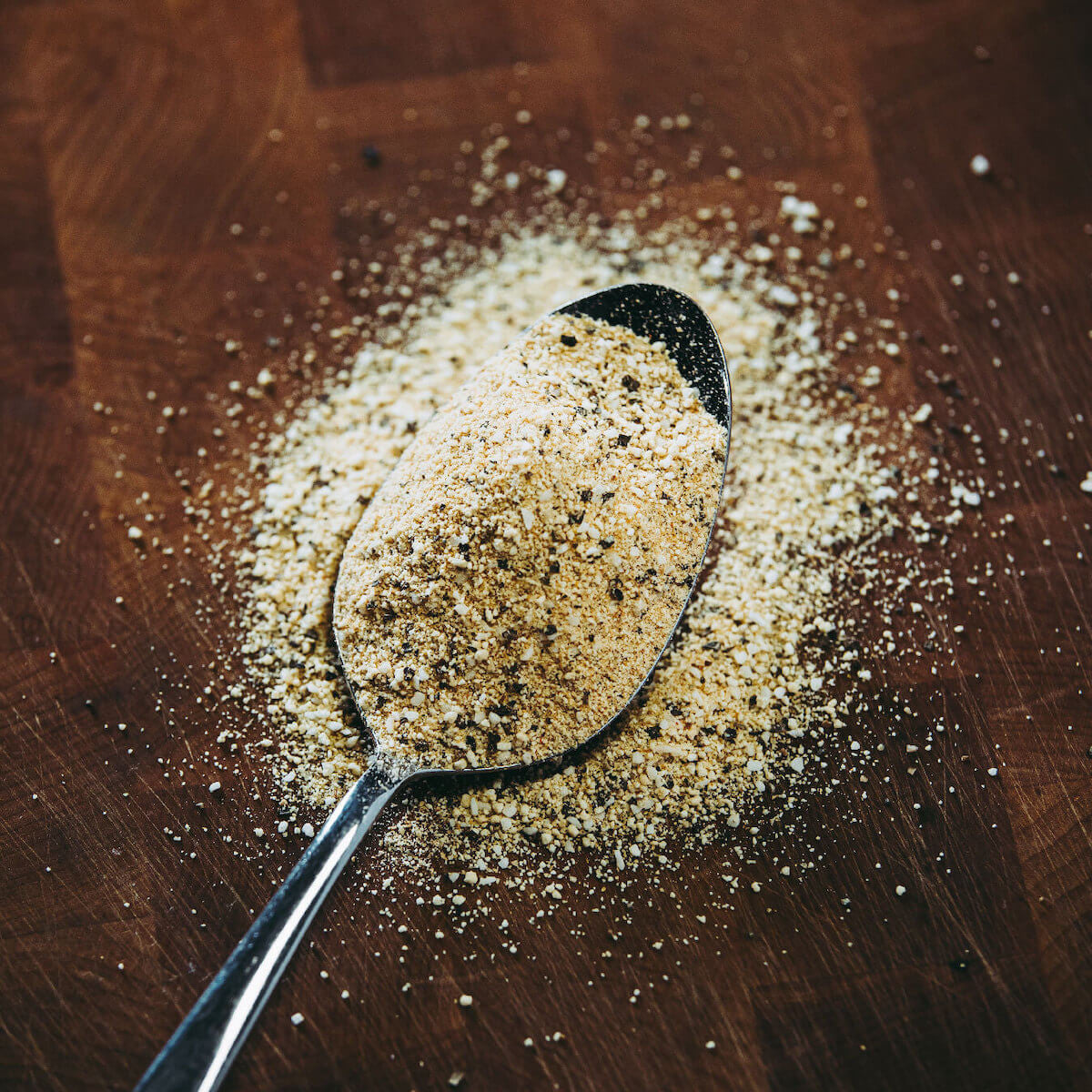 Jody's Asian Persuasion Rub on spoon showing the spice out of bottle.