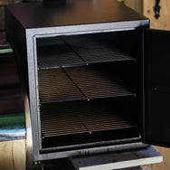 Smokebox RT-1250 & RT-700 attached to grill with door open showing the 3 shelves inside.