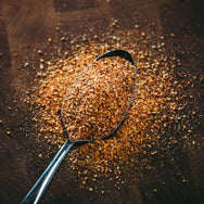Ron's Screamin' Pig Rub on spoon showing the spice out of bottle.
